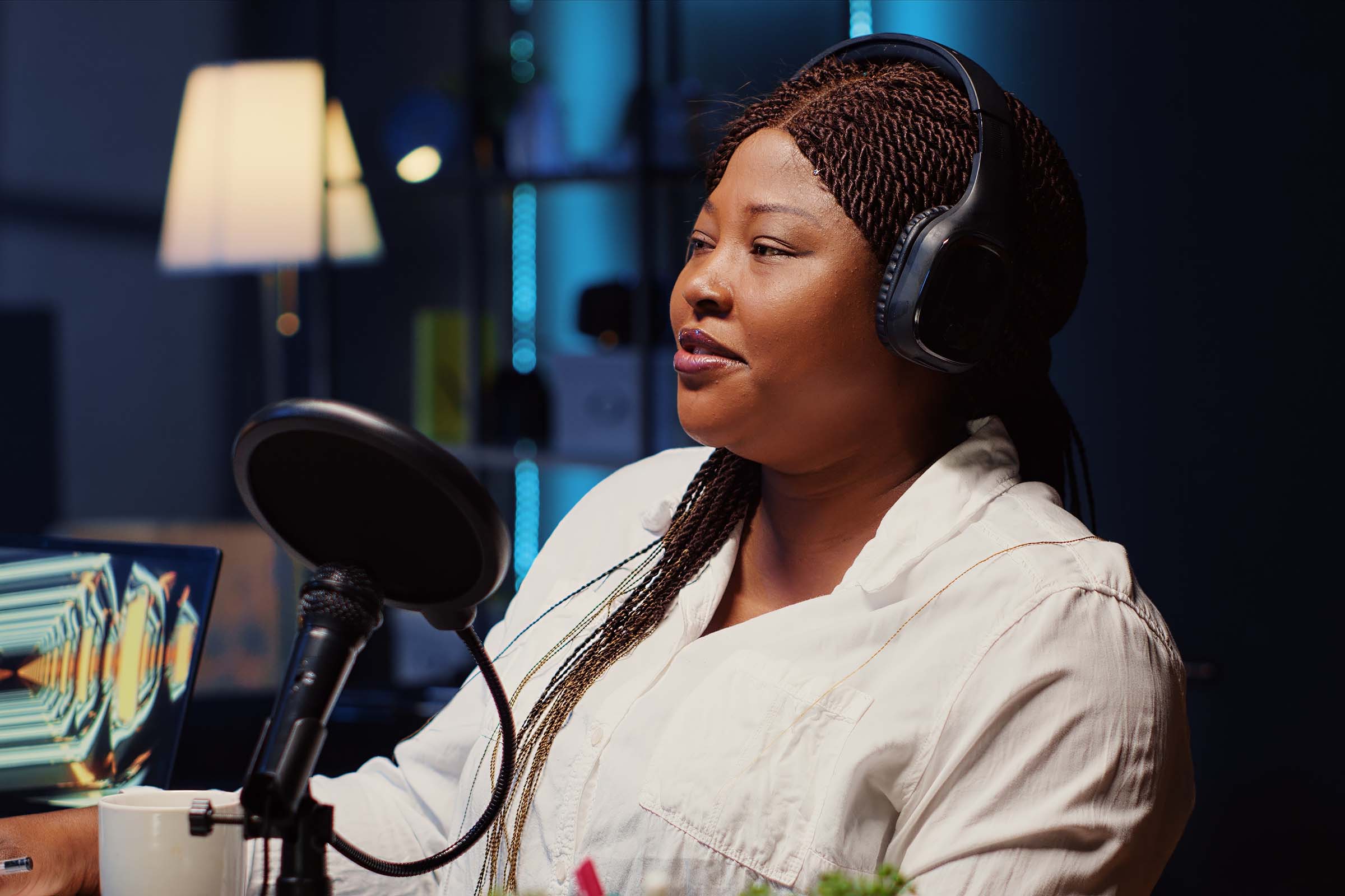 Guest on online podcast show telling interesting story to host, captivating viewers watching during live broadcast. African american woman in studio sharing facts, surrounded by audio tech